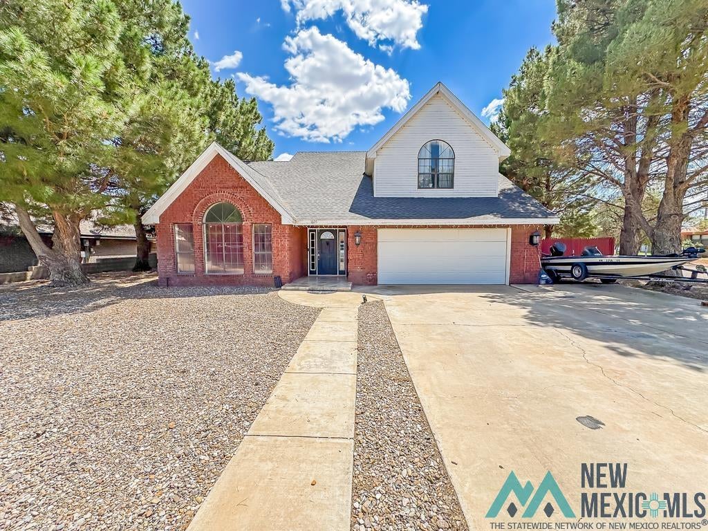 1605 South Avenue Avenue Eunice, NM 88231 - Photo 1 of 1 Traditional-style house featuring an attached garage, brick siding, concrete driveway, and roof with shingles