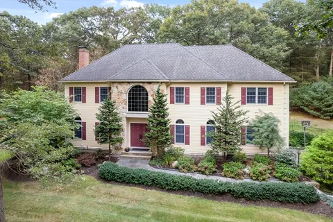 a front view of a house with a yard and potted plants
