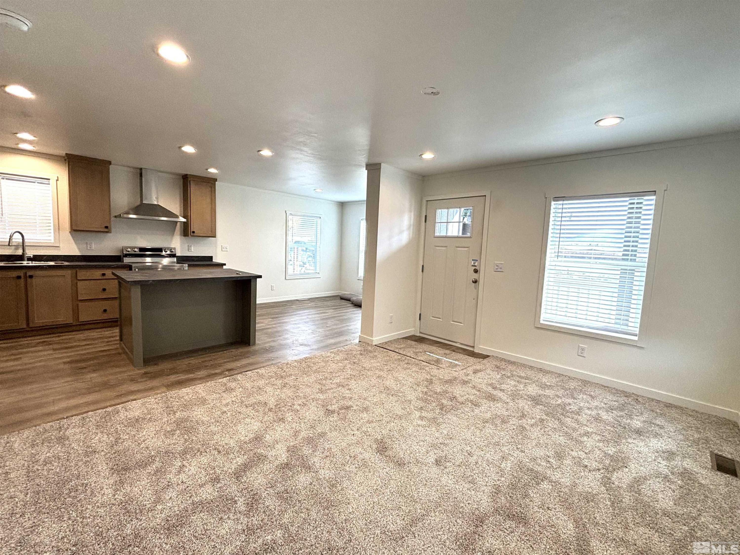 475 Camellia Way Lovelock, NV 89419 - Photo 3 of 23 a kitchen with stainless steel appliances granite countertop a stove top oven a sink dishwasher and a refrigerator with wooden floor
