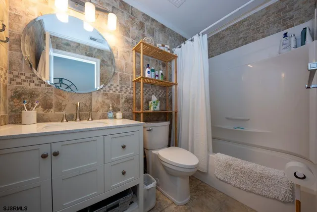 a bathroom with a granite countertop toilet sink and mirror