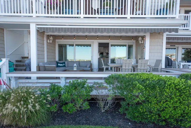 a view of a house with potted plants and a bench