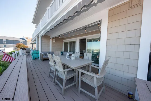 a view of a patio with table and chairs with wooden floor and fence