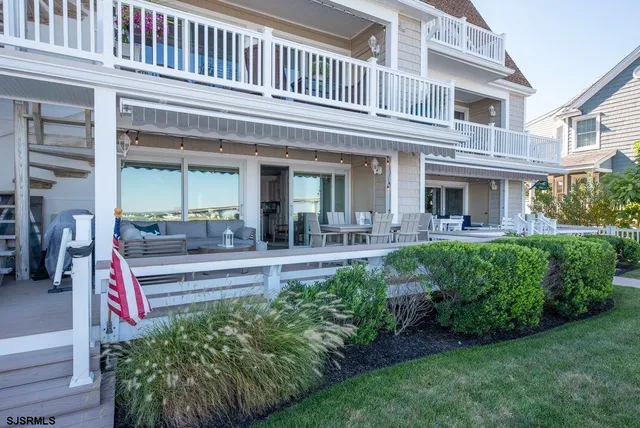a view of a house with a small yard plants and large tree