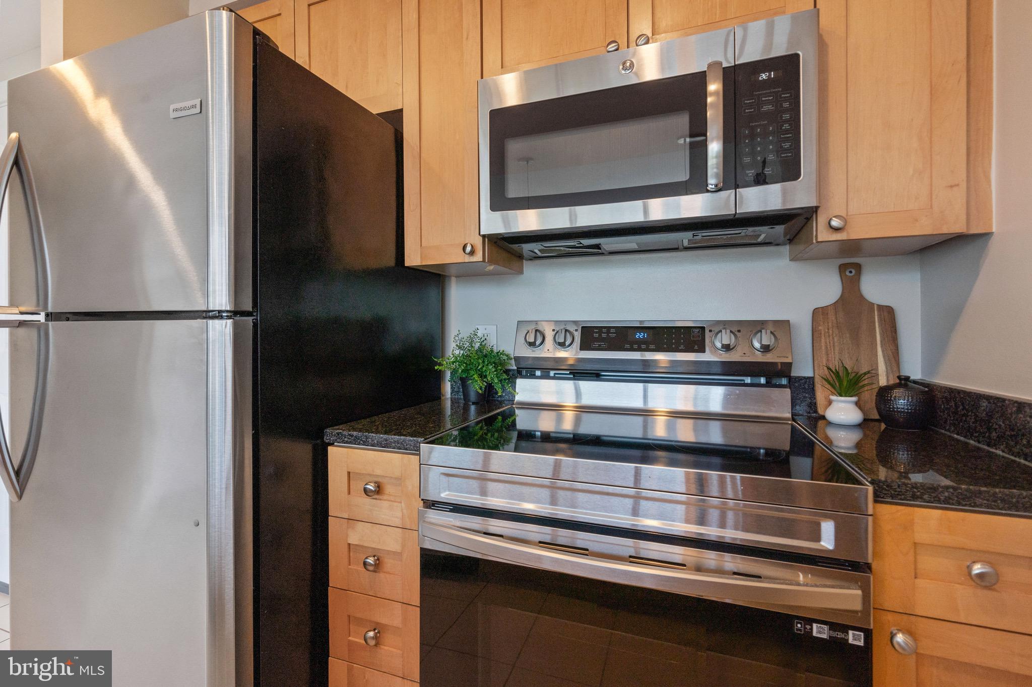 2001 15th Street North, Unit 306 Arlington, VA 22201 - Photo 11 of 56 a kitchen with stainless steel appliances granite countertop a refrigerator and a microwave