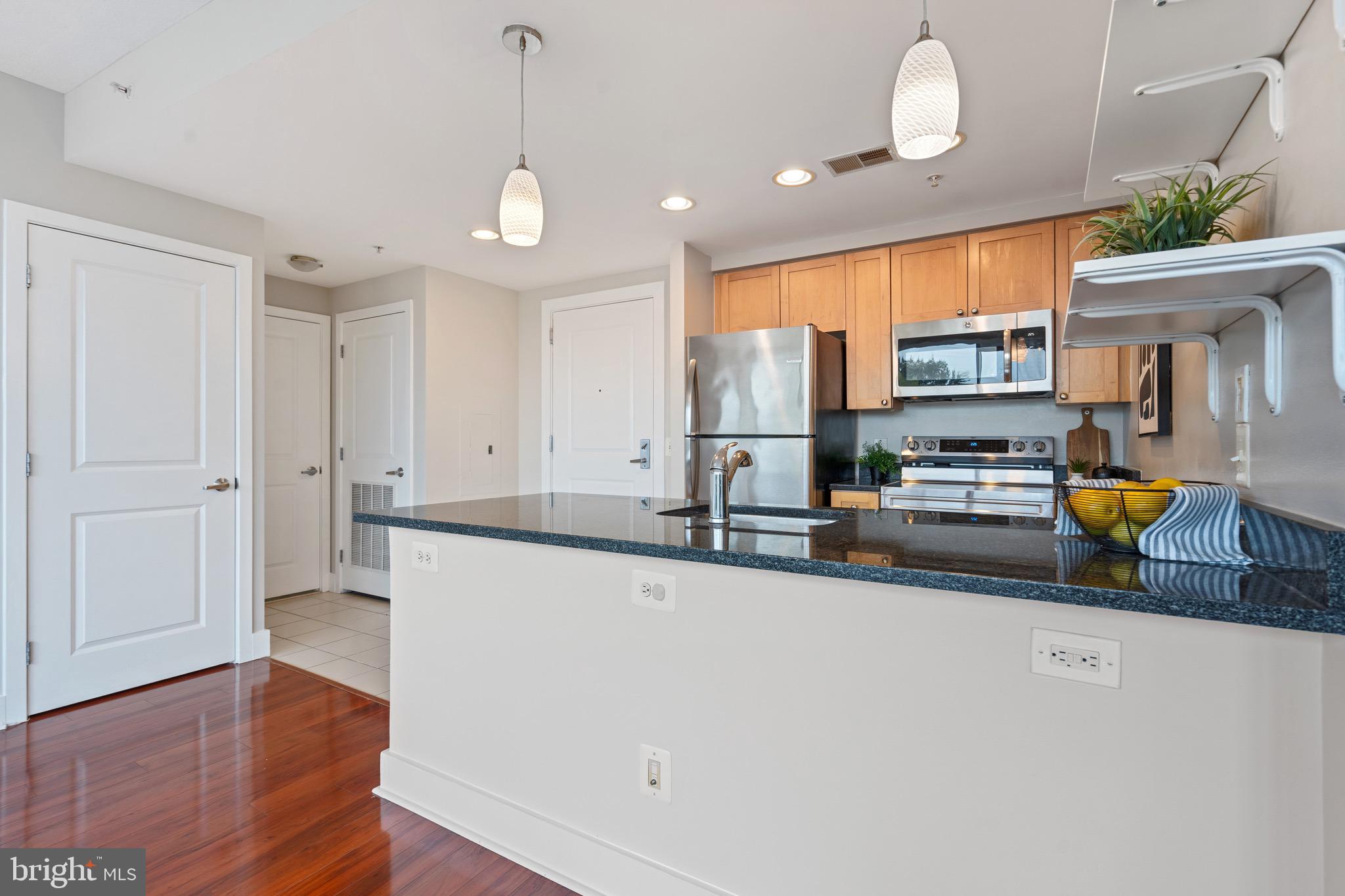2001 15th Street North, Unit 306 Arlington, VA 22201 - Photo 28 of 56 a kitchen with stainless steel appliances a stove a sink a refrigerator white cabinets and wooden floor