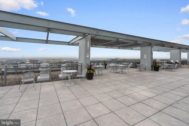 a dining hall with stainless steel appliances granite countertop a stove and a view of living room with windows