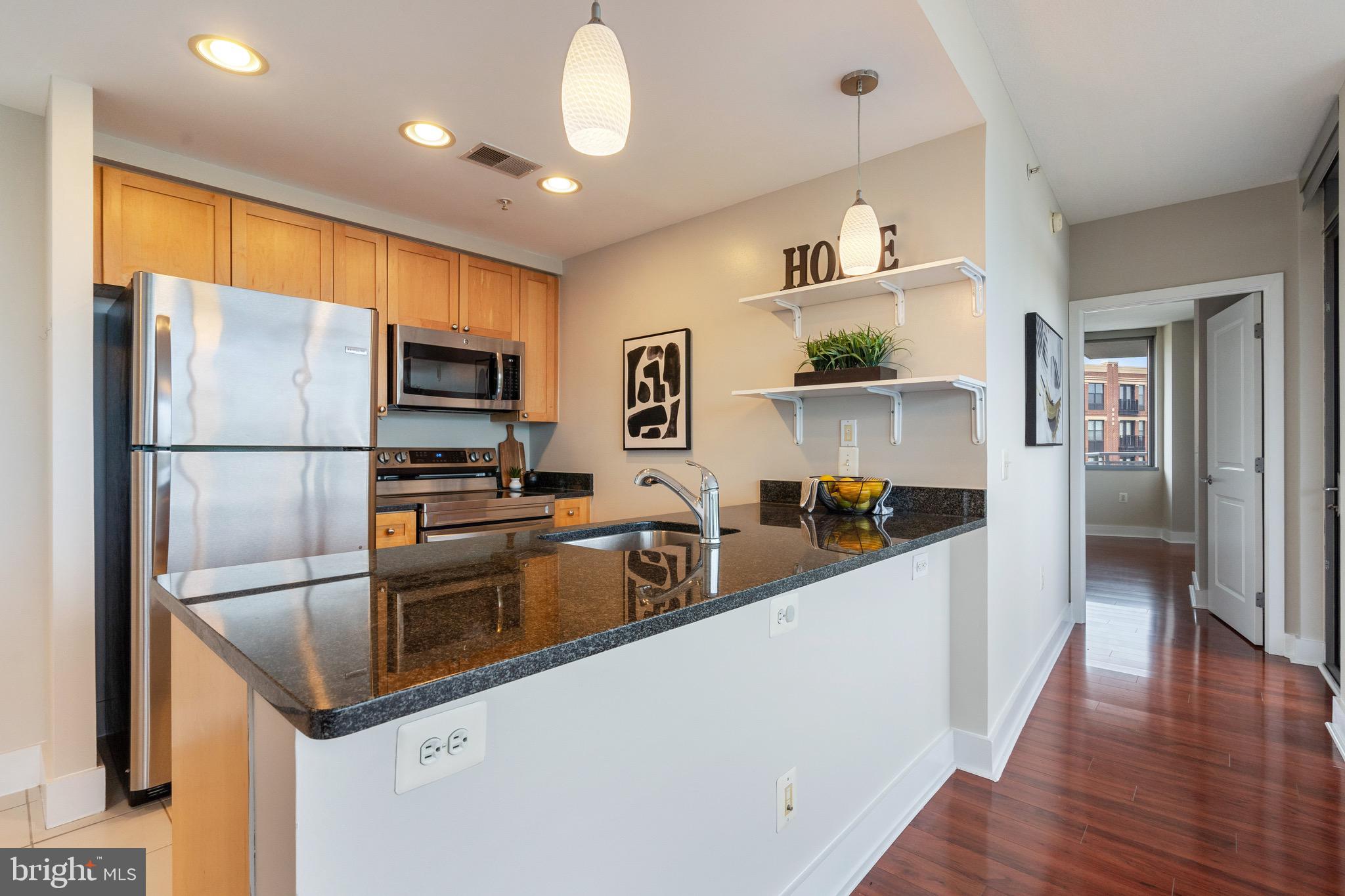2001 15th Street North, Unit 306 Arlington, VA 22201 - Photo 9 of 56 a kitchen with stainless steel appliances granite countertop a refrigerator and a stove top oven