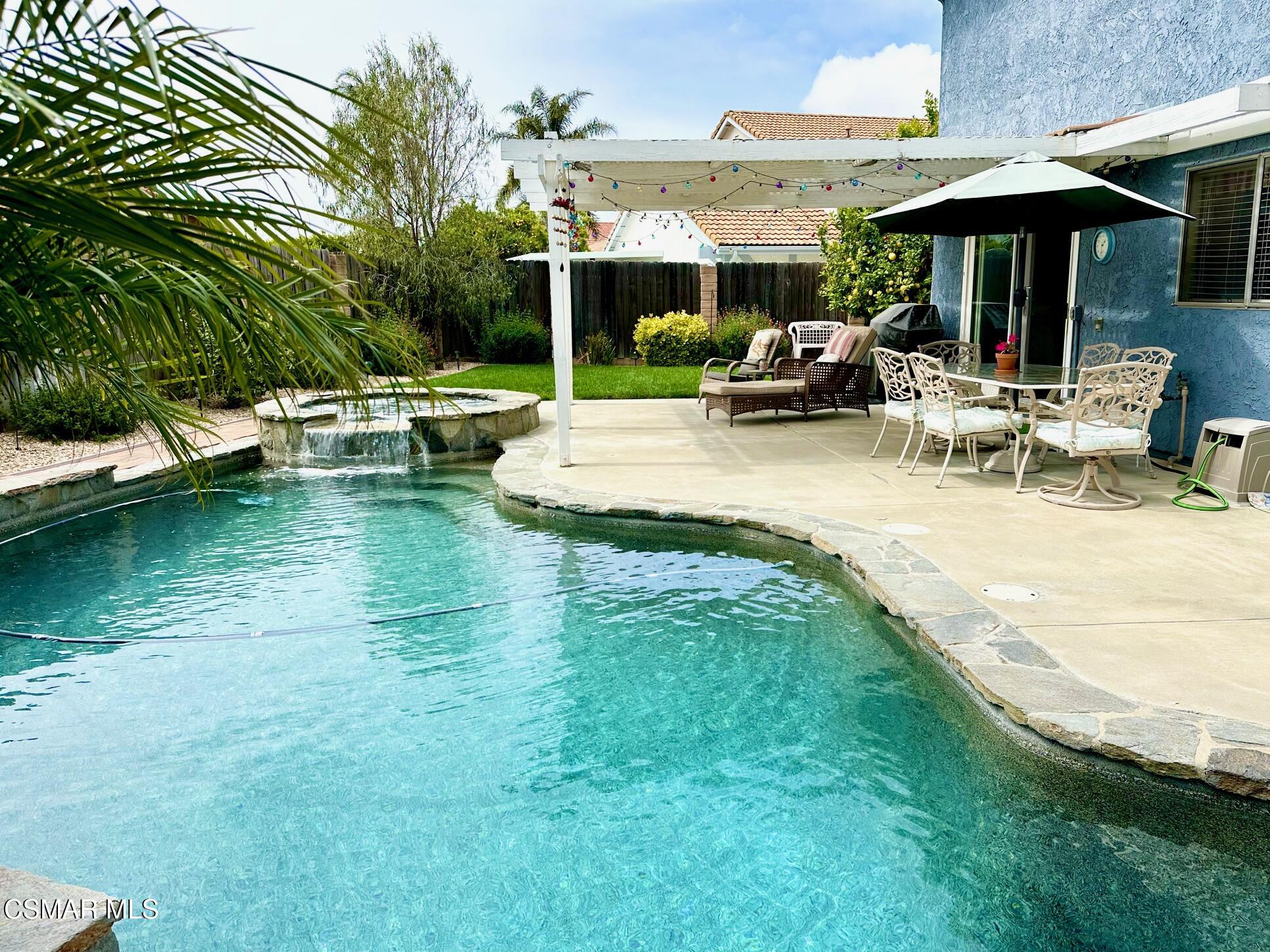 6464 Hazel Circle Simi Valley, CA 93063 - Photo 1 of 42 a view of a swimming pool with a table and chairs under an umbrella