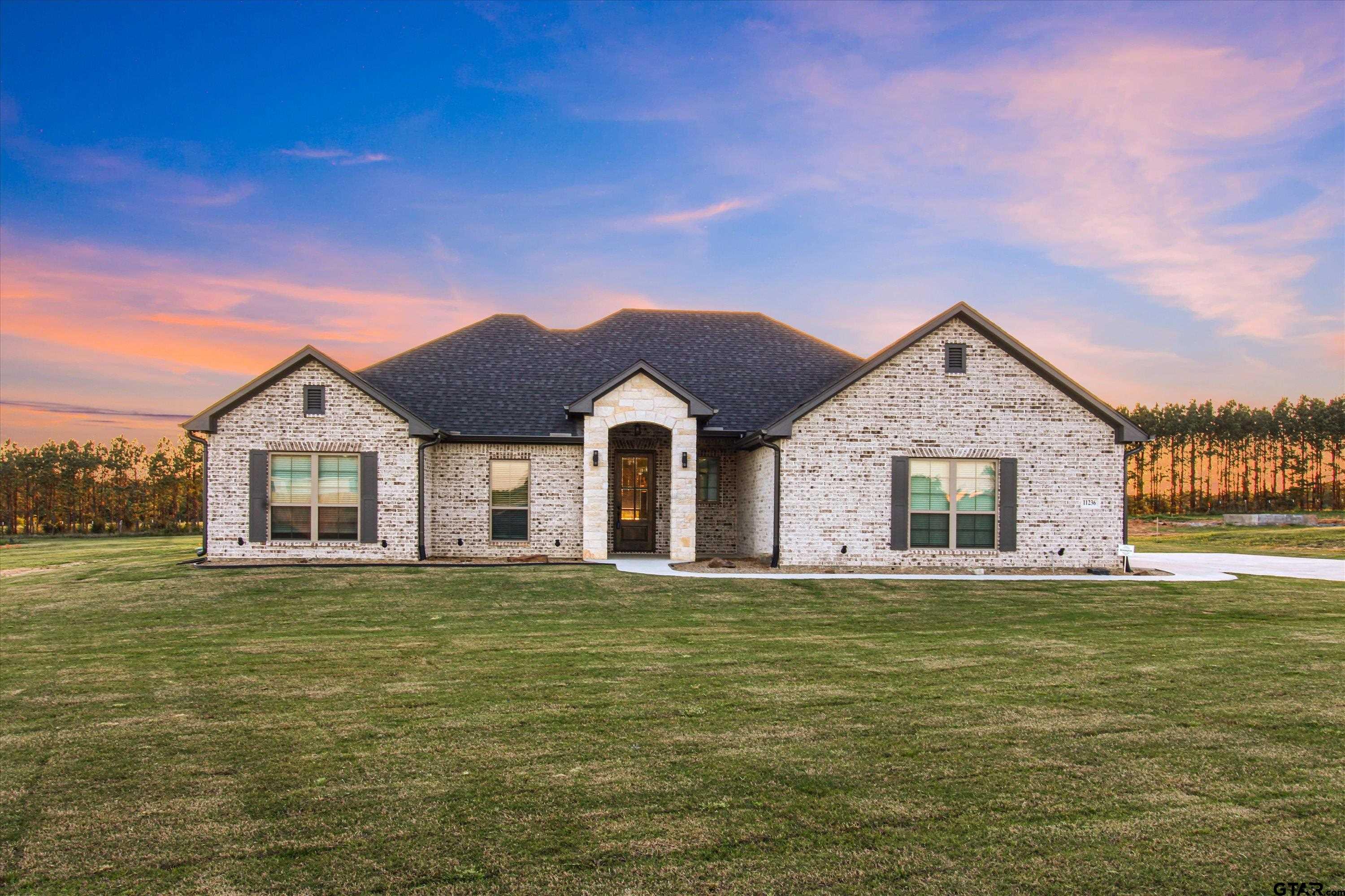 a large house with a big yard and large trees