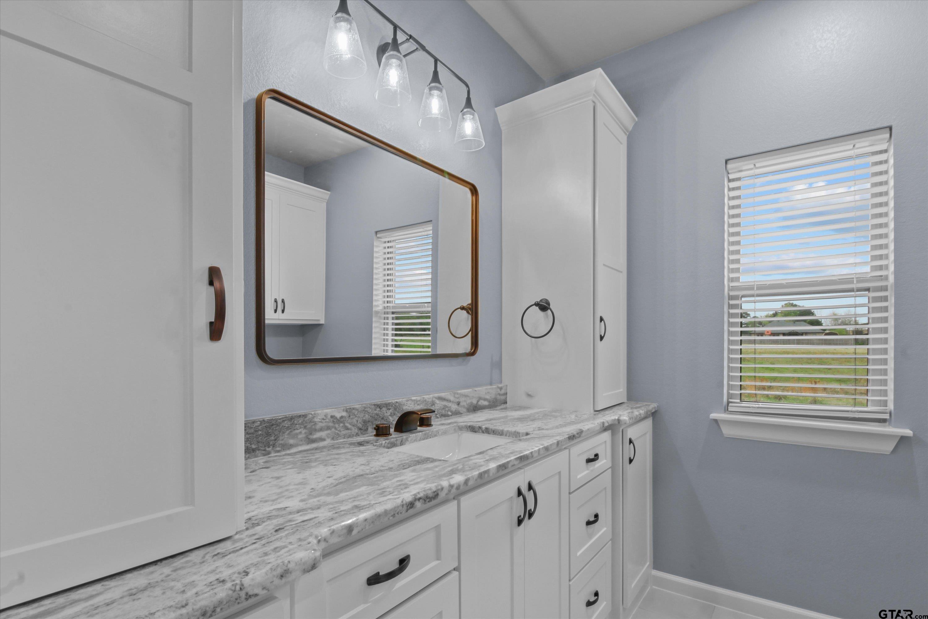 11236 Bryce Circle Flint, TX 75762 - Photo 23 of 44 a bathroom with a granite countertop sink and a mirror