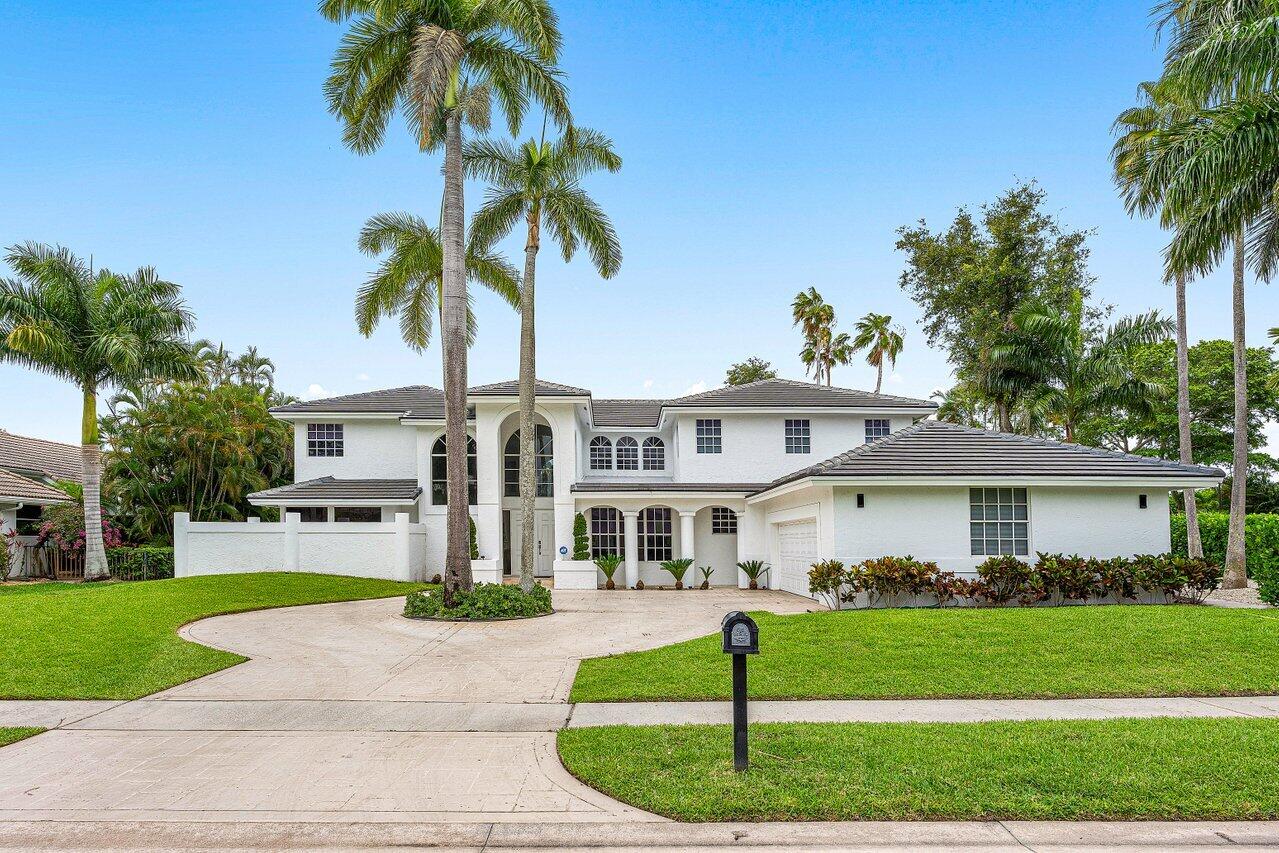 2197 Northwest 59th Street Boca Raton, FL 33496 - Photo 1 of 62 a front view of a house with a garden and palm trees