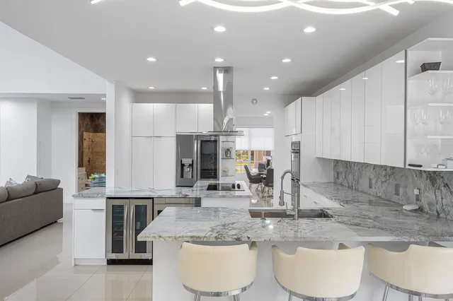 a kitchen with stainless steel appliances granite countertop a white cabinets a sink and a stove