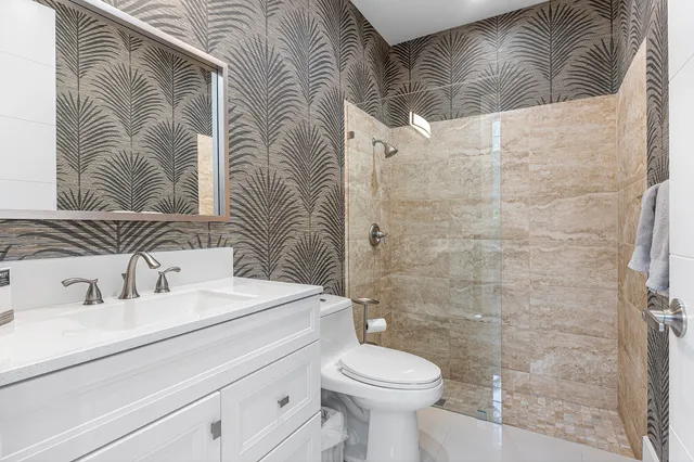 a bathroom with a sink a toilet and shower