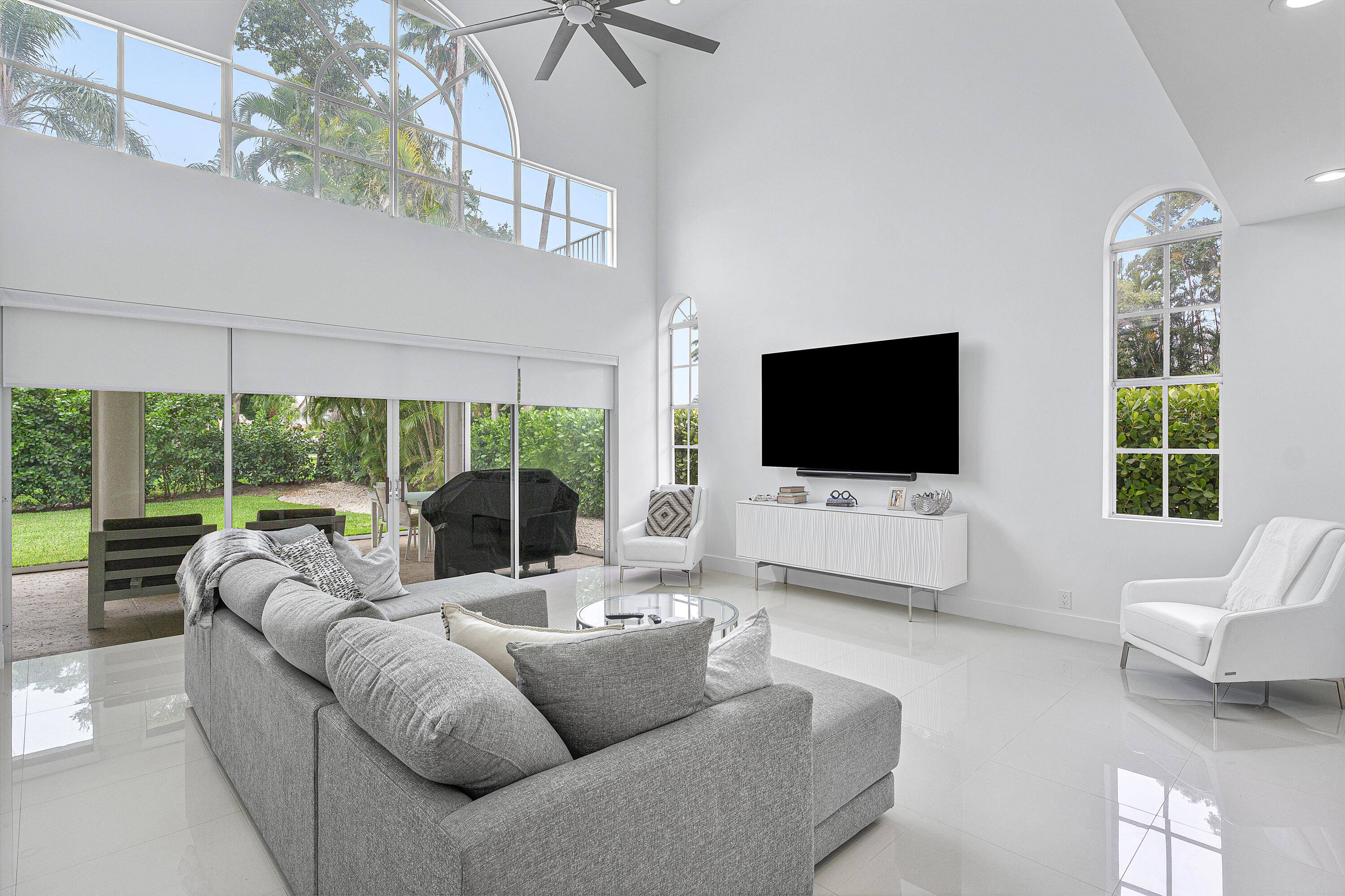 2197 Northwest 59th Street Boca Raton, FL 33496 - Photo 14 of 62 a living room with furniture a flat screen tv and a floor to ceiling window