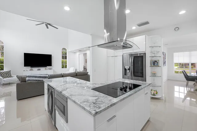 a kitchen with stainless steel appliances kitchen island granite countertop a sink and chairs