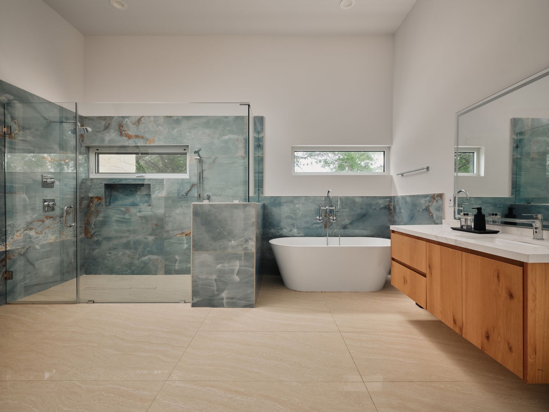2476 Waymaker Way Austin, TX 78746 - Photo 12 of 31 Clean lines define this generous primary bathroom, featuring a freestanding tub and spacious walk-in shower.