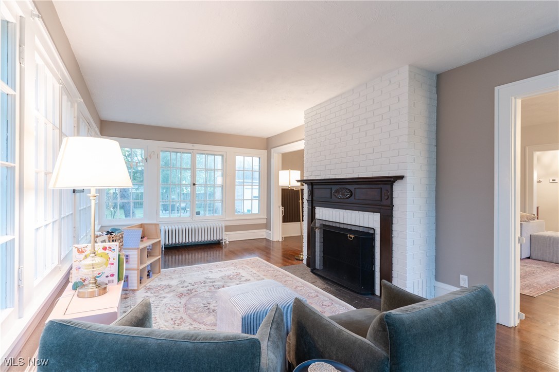 2890 Huntington Road Cleveland, OH 44120 - Photo 14 of 41 Living room with radiator heating unit, a brick fireplace, and dark hardwood / wood-style floors