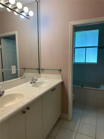 a bathroom with a granite countertop sink a toilet and a mirror