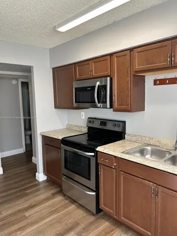 a kitchen with granite countertop a stove and a microwave