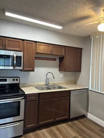 a kitchen with granite countertop a sink and a stove top oven