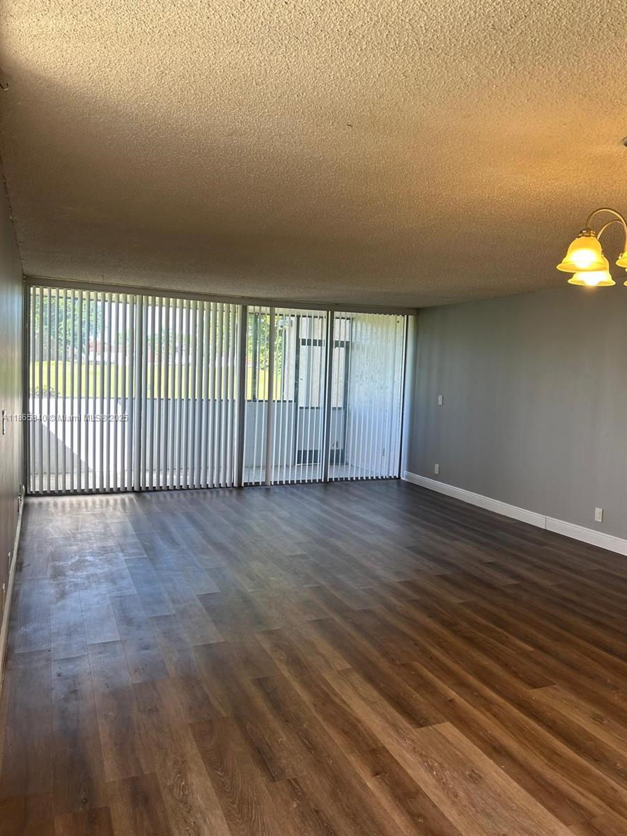 3671 Environ Boulevard, Unit 164 Lauderhill, FL 33319 - Photo 3 of 27 an empty room with wooden floor and windows