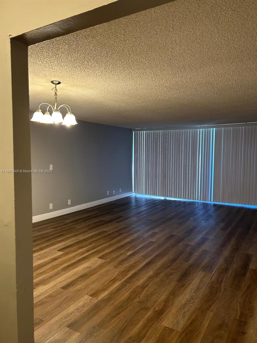 3671 Environ Boulevard, Unit 164 Lauderhill, FL 33319 - Photo 4 of 27 an empty room with wooden floor and windows