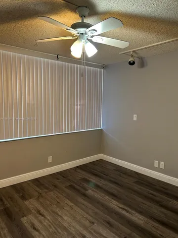 a room with wooden floor and white walls
