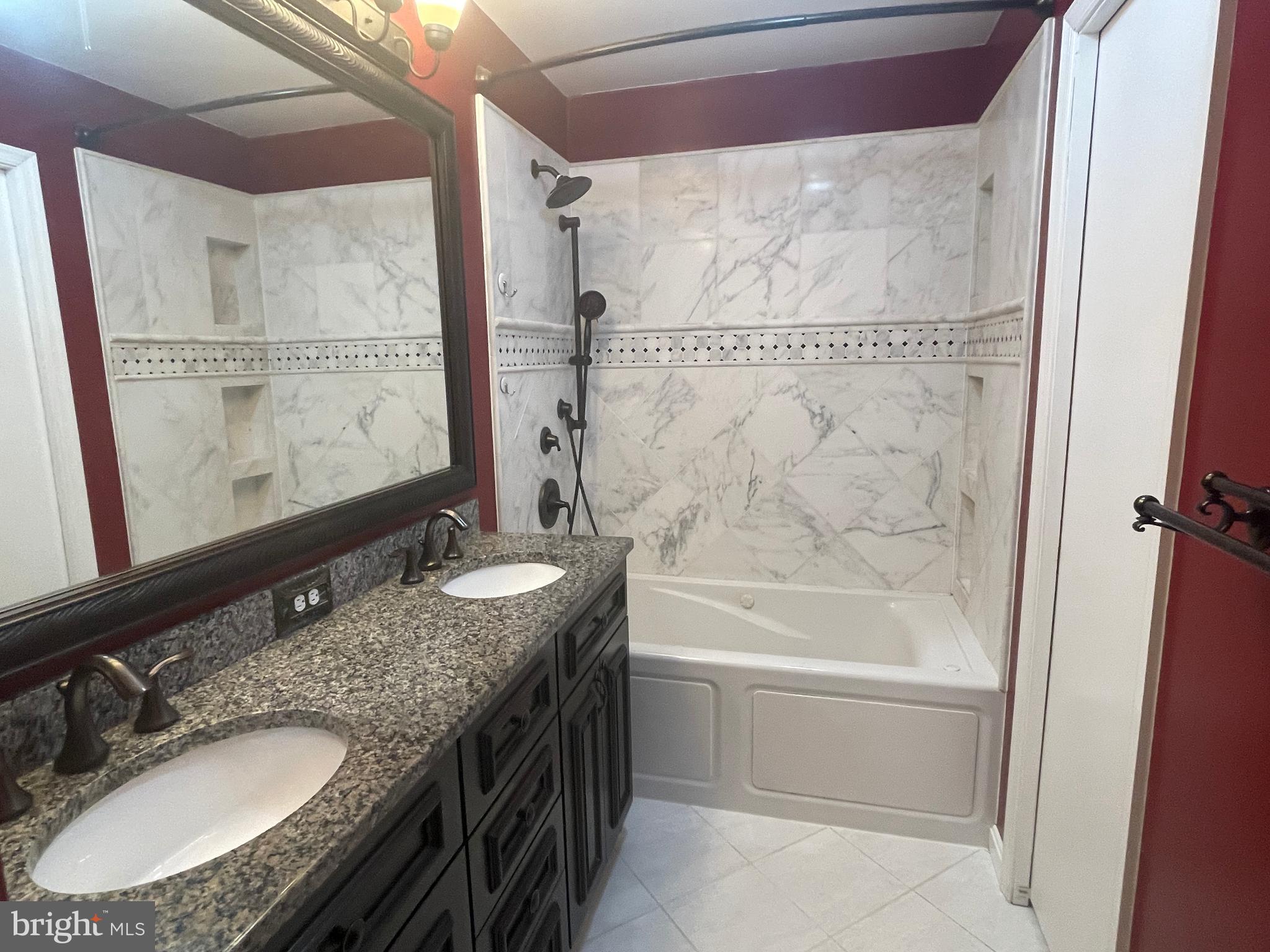7809 Lake Drive Manassas, VA 20111 - Photo 28 of 44 a bathroom with a granite countertop sink a mirror a bathtub and shower