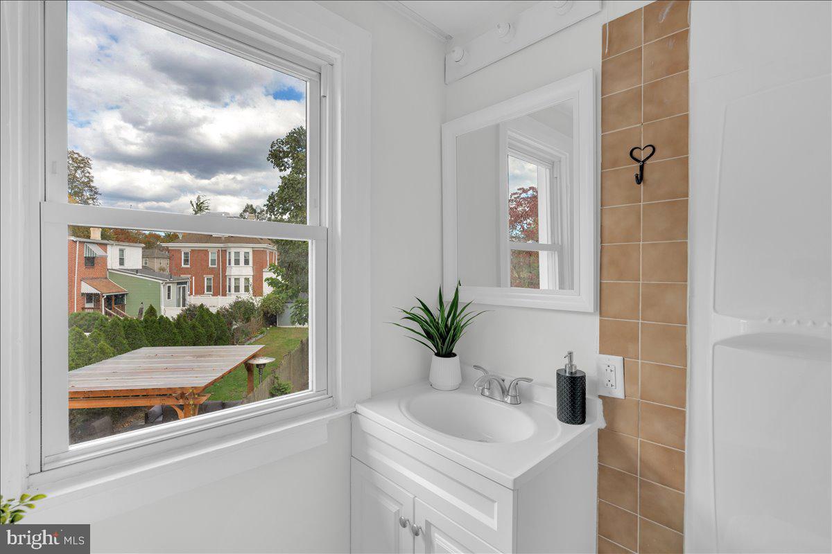 111 Ellis Street Haddonfield, NJ 08033 - Photo 15 of 20 a bathroom with a sink a mirror and next to a window
