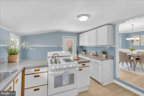 a kitchen with a stove cabinets and wooden floor