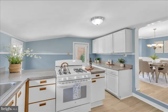 a kitchen with a stove cabinets and wooden floor
