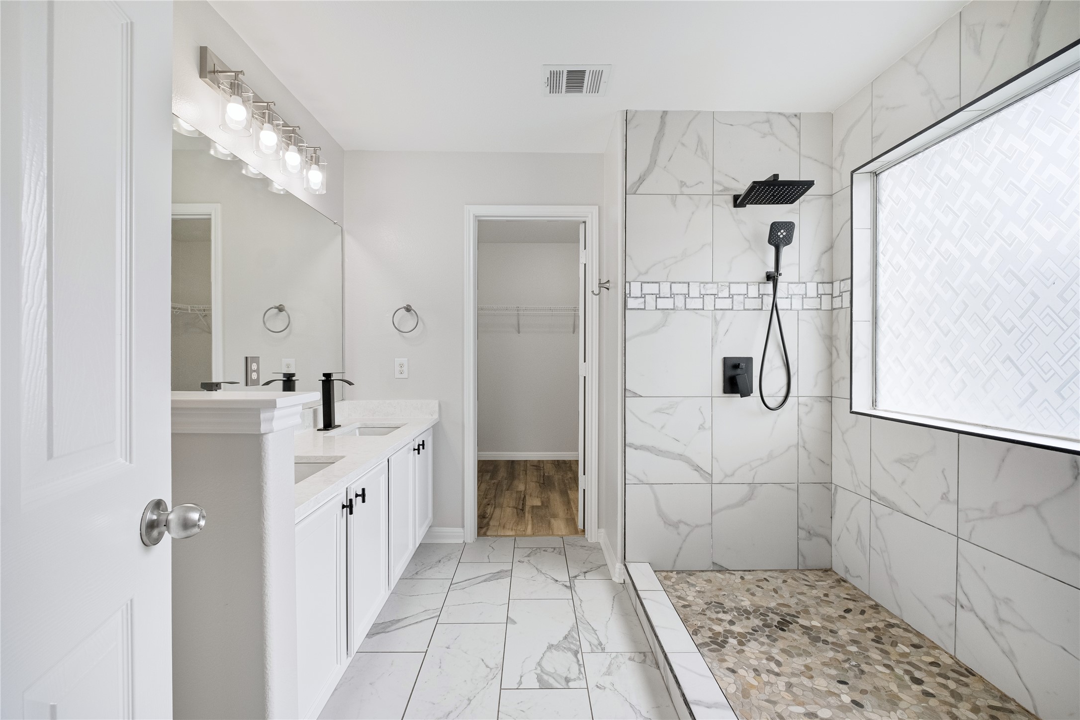 1400 Portchester Castle Path Pflugerville, TX 78660 - Photo 23 of 40 Full bath with a marble finish shower, a walk in closet, light marble finish flooring, and double vanity