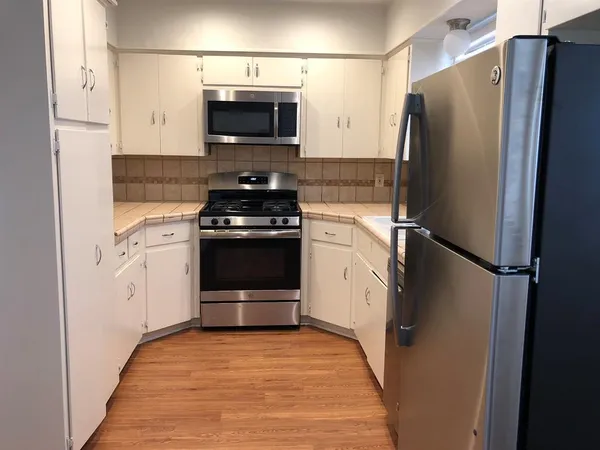 a kitchen with stainless steel appliances a refrigerator stove and microwave