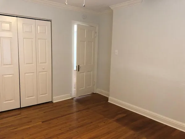 a view of an empty room with wooden floor