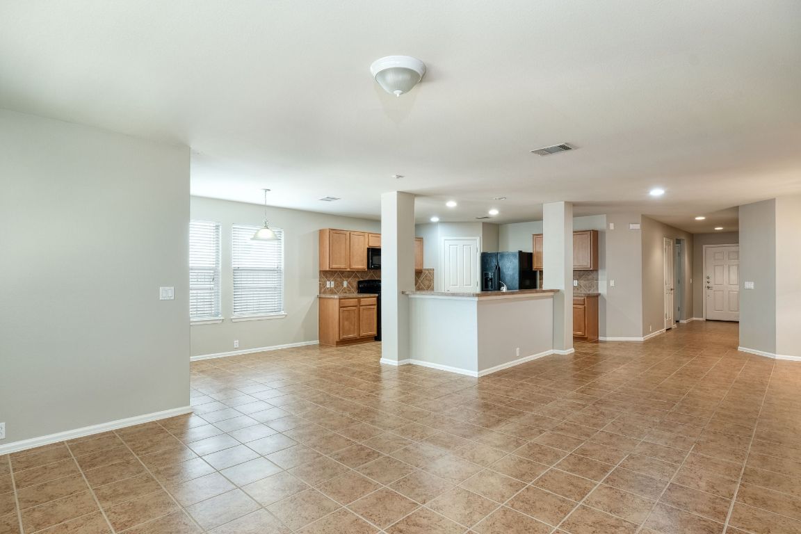 409 Lark Street Leander, TX 78641 - Photo 3 of 14 a view of an empty room and kitchen with kitchen island granite top oven