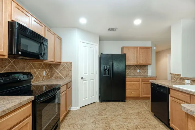 a kitchen with stainless steel appliances granite countertop a stove a refrigerator and a microwave