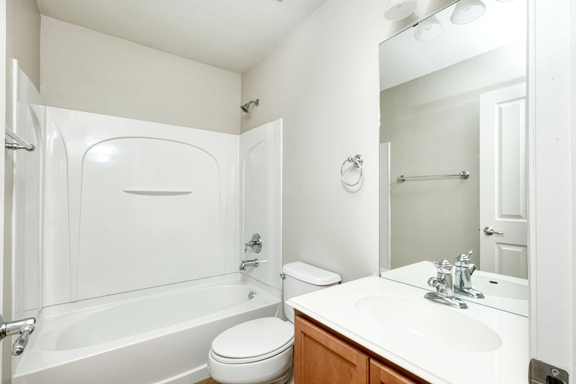 409 Lark Street Leander, TX 78641 - Photo 10 of 14 a bathroom with a sink a toilet and shower