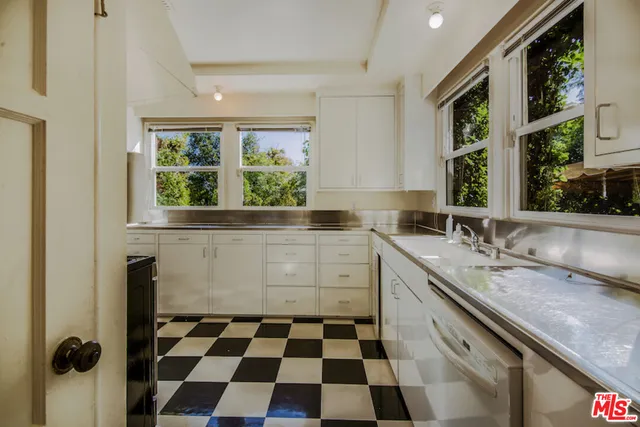 a kitchen with a sink a stove a shower and a window