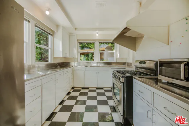 a kitchen with a sink a stove a microwave and cabinets