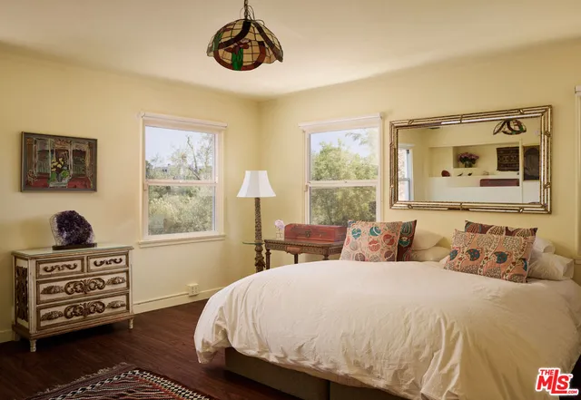 a bedroom with a bed and dresser with mirror