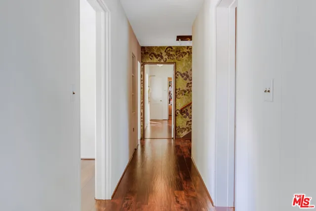 a view of a hallway with wooden floor