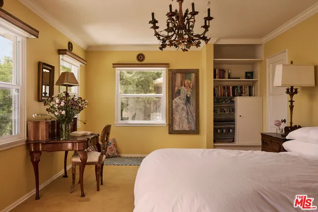 a bedroom with a bed and a table chair