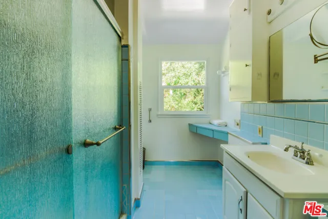a bathroom with a sink and mirror with toilet
