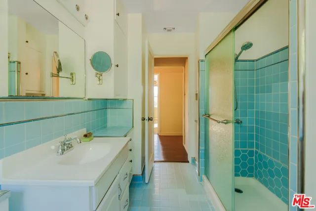 a bathroom with a sink mirror and shower