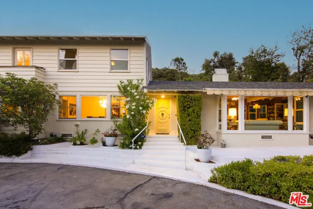 a view of a house with potted plants and a tree