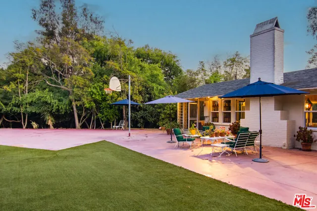 a patio with a table and chairs under an umbrella