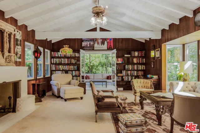 a living room with furniture a window and bookshelf