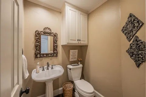 a bathroom with a toilet sink and mirror