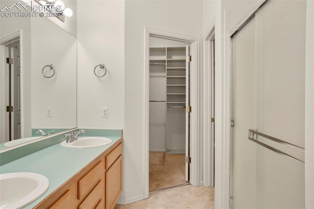 1244 Samuel Point Colorado Springs, CO 80906 - Photo 14 of 22 a bathroom with a granite countertop sink two mirror and a shower