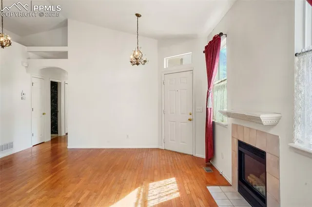 a view of empty room with wooden floor and fireplace
